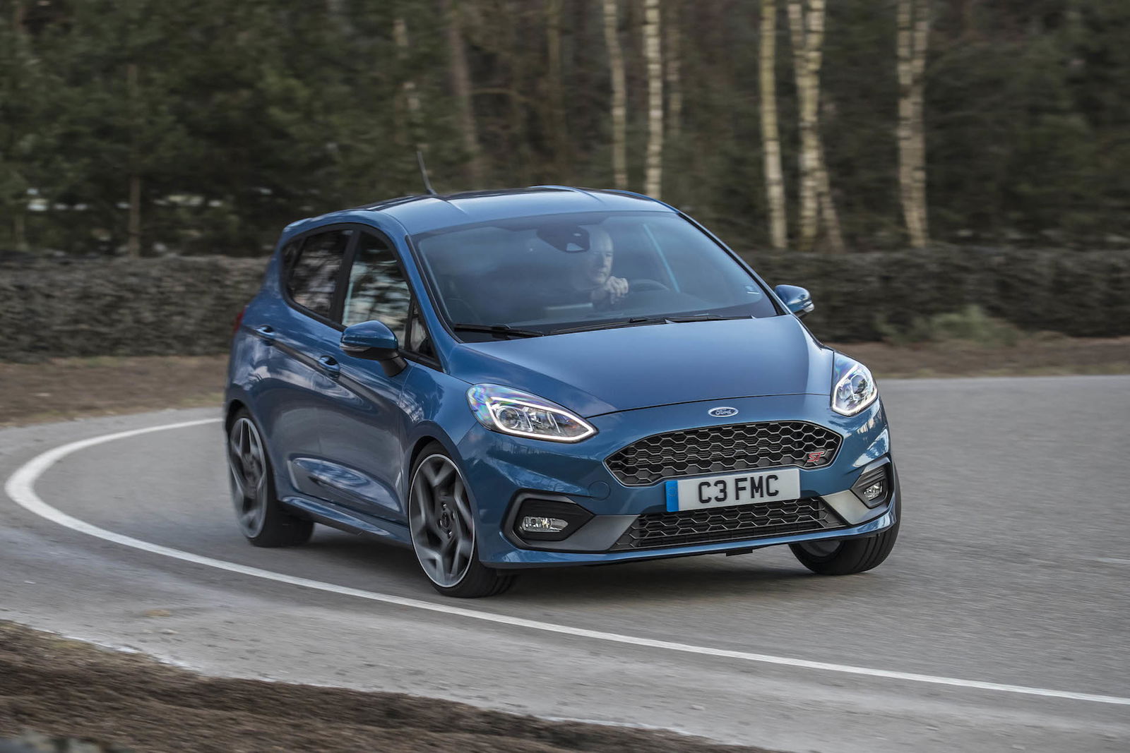 nuova ford fiesta st blu curva impegnata alberi