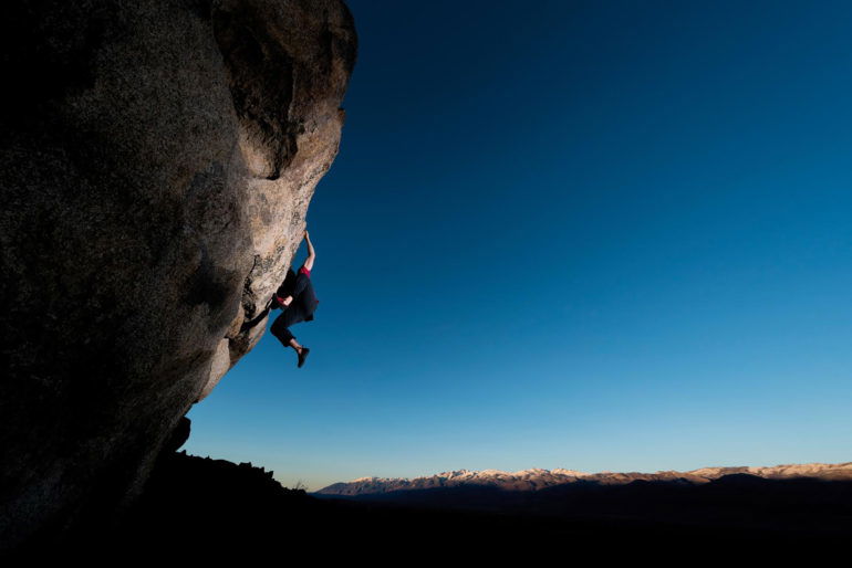 strong rock climber on a steep boulder during sunset, Location, Bishop CA USA