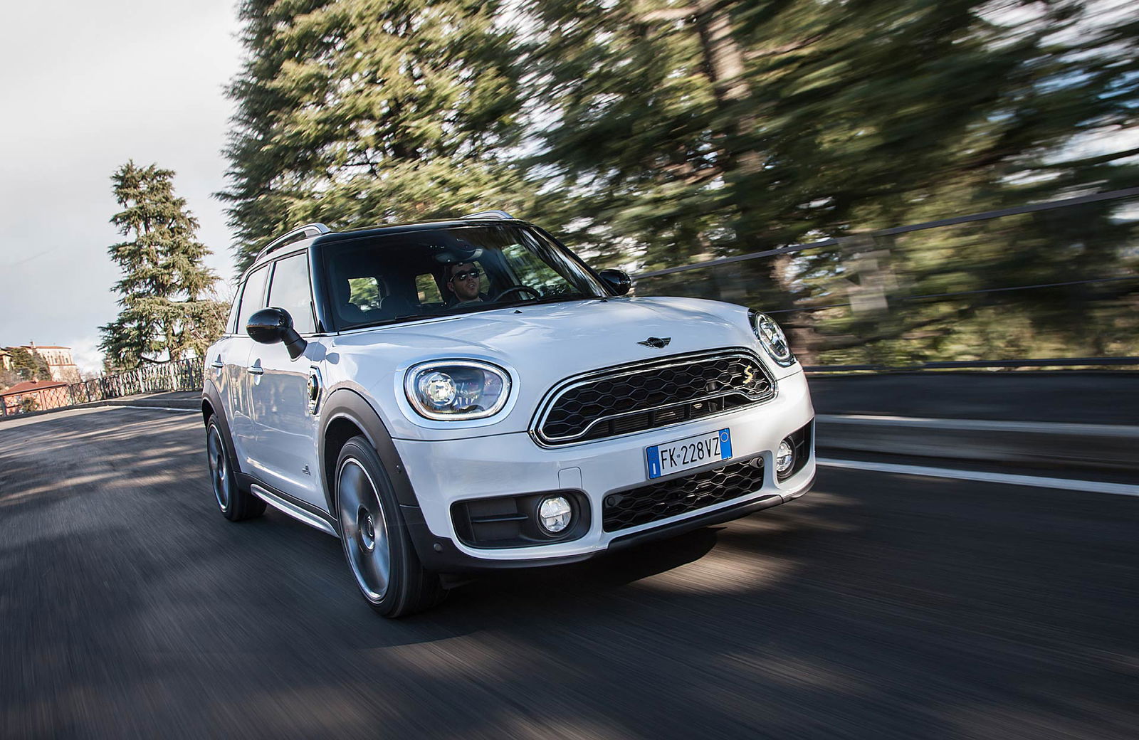 Mini Cooper Countryman SE bianca viaggia immersa tra gli alberi