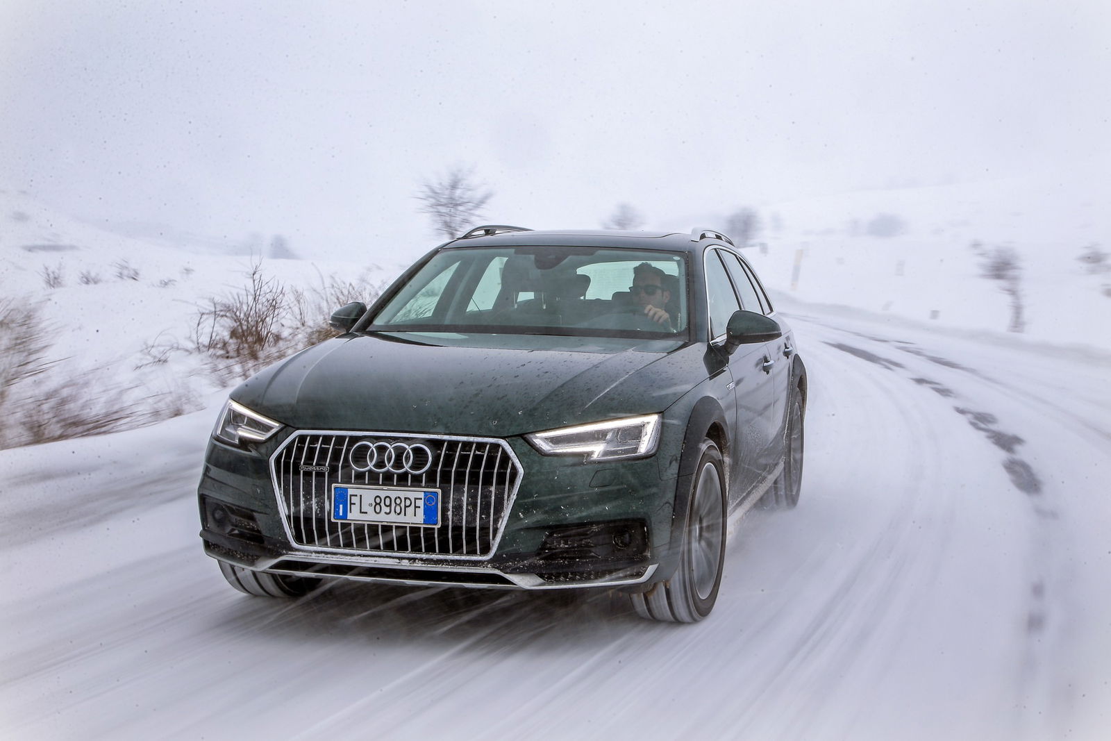 Audi A4 allroad quattro verde percorre una strada di montagna innevata