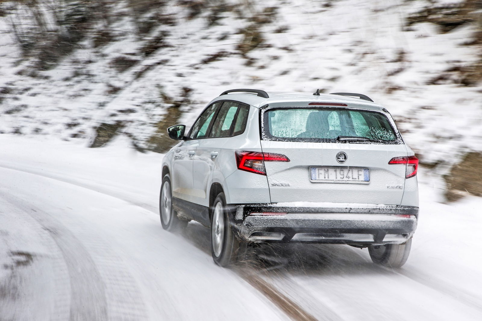 Skoda Karoq vista posteriore in curva su strada innevata