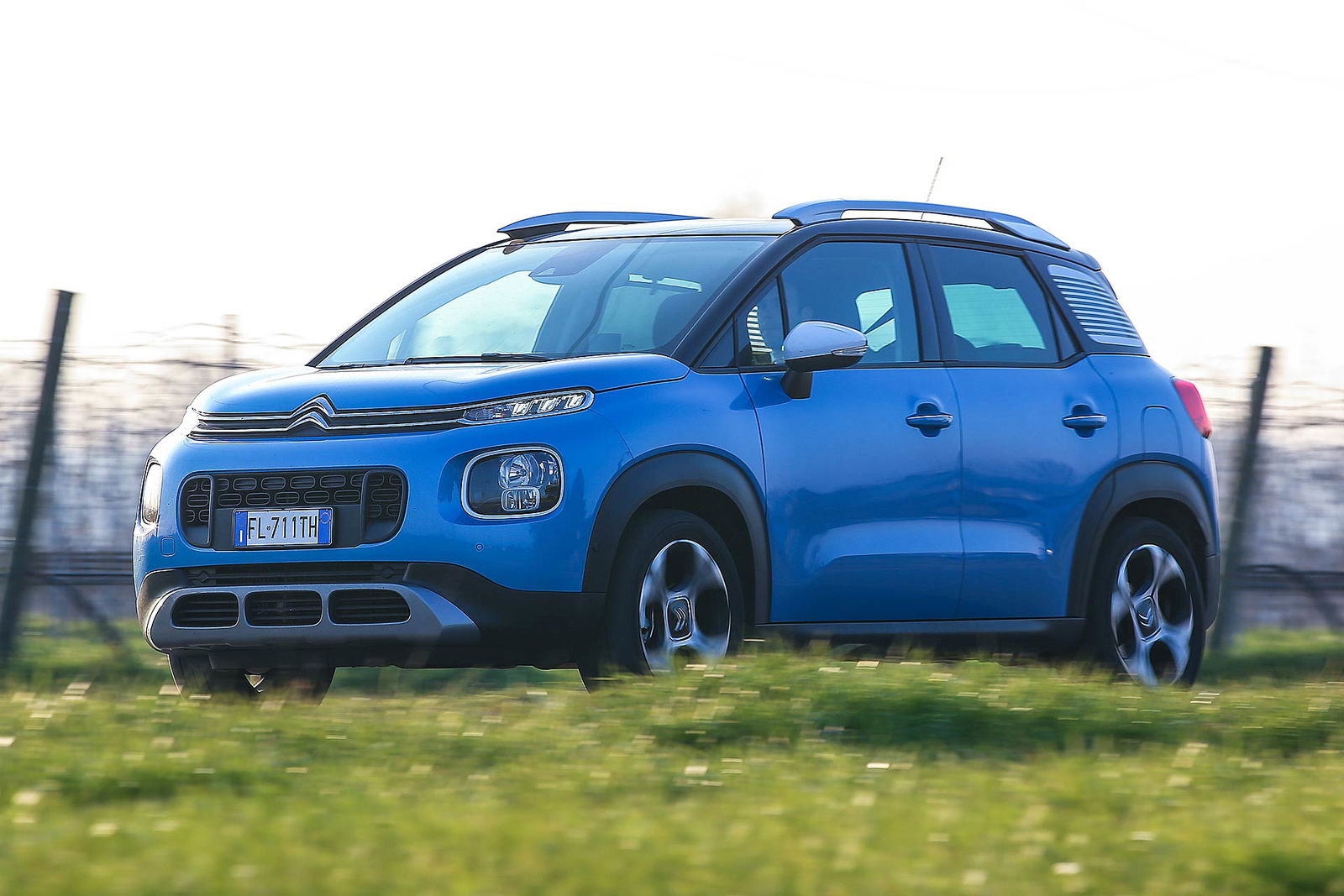 Citroën C3 Aircross azzurra vista tre quarti con prato verde e staccionata