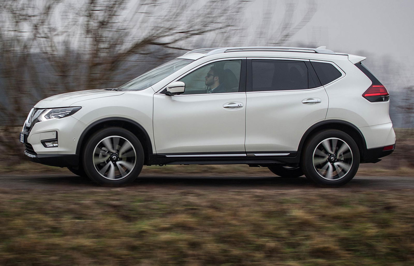 Nissan X-Trail 1.6 dCi 130 CVT 2WD Tekna vista laterale in paesaggio di campagna