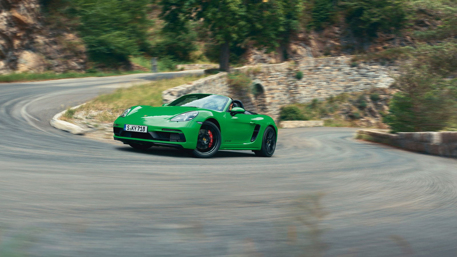 porsche 718 GTS 4.0 Boxster verde in azione su curva di montagna